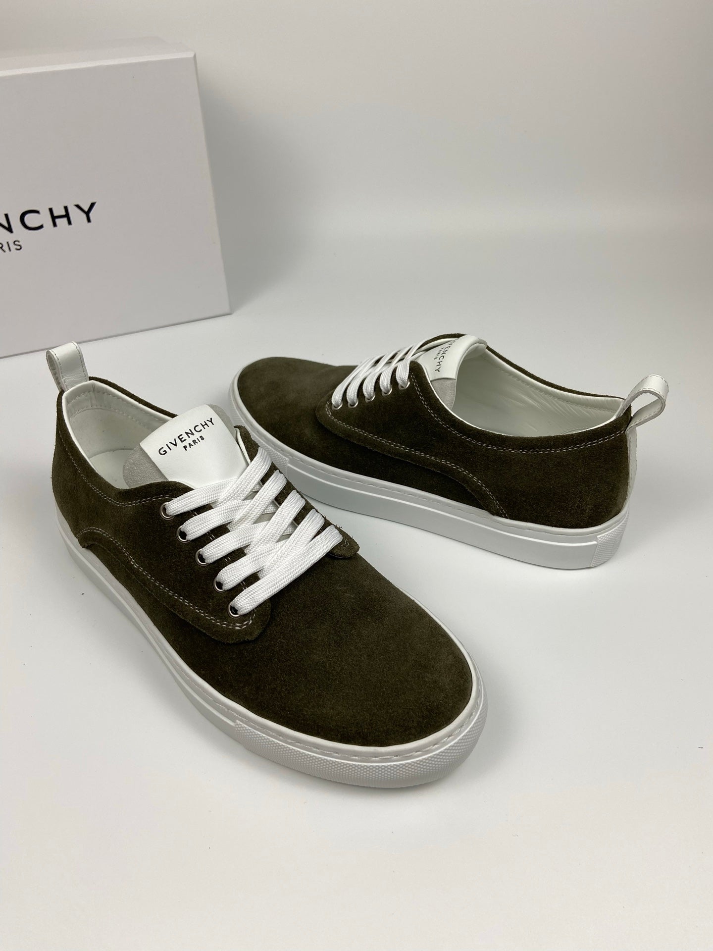 Olive suede sneakers shown from side angles, white laces and white rubber soles.
