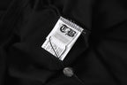 Black long-sleeve shirt fabric with white interior neck label and care tag