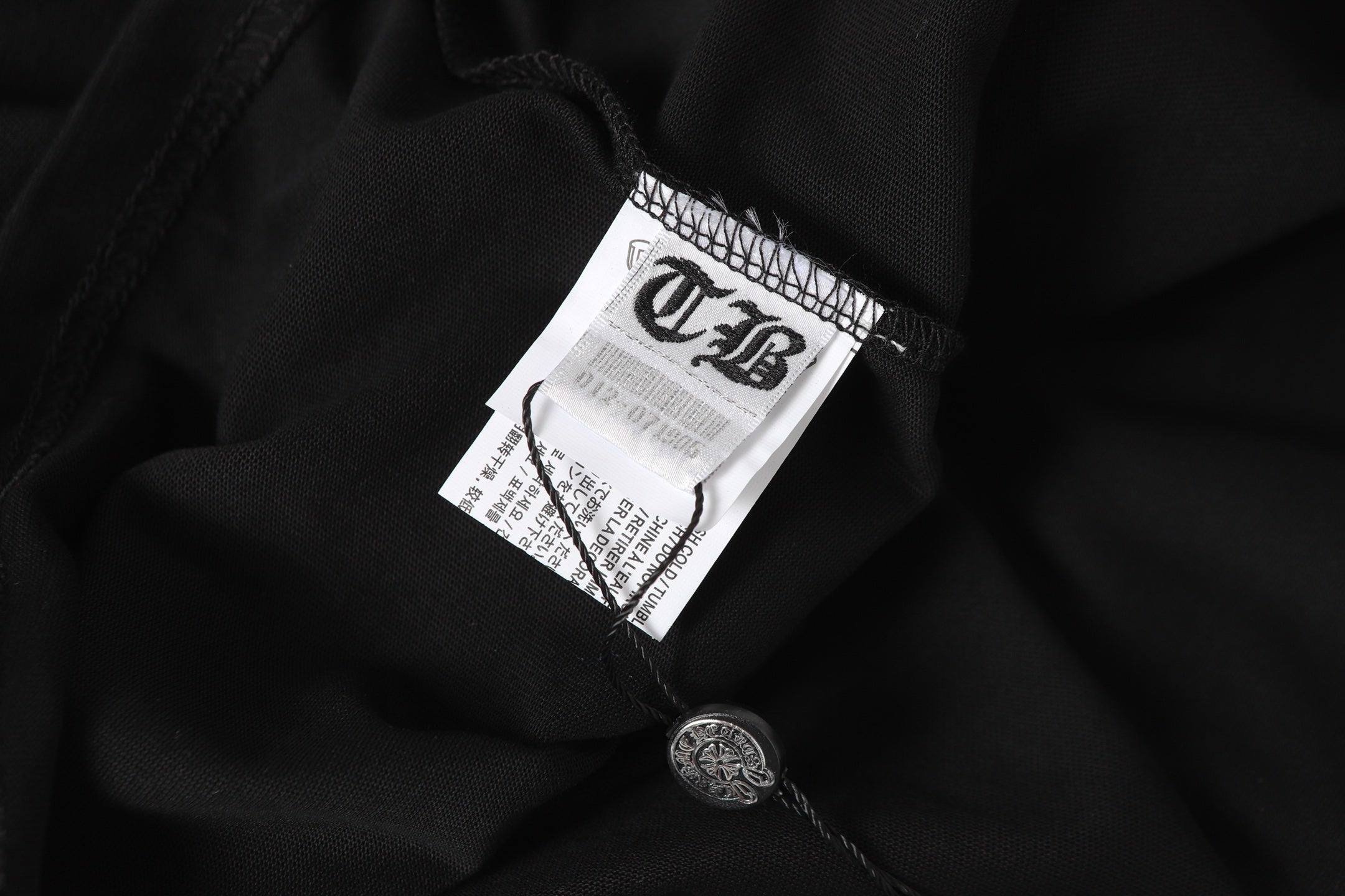 Black long-sleeve shirt fabric with white interior neck label and care tag