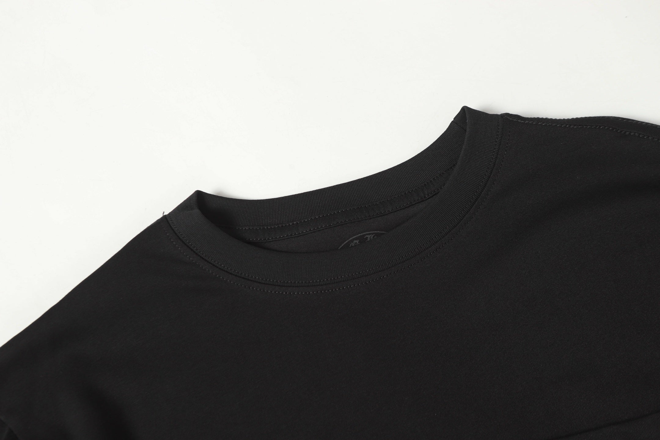 Black long-sleeve shirt neckline with ribbed collar and neat stitched seam