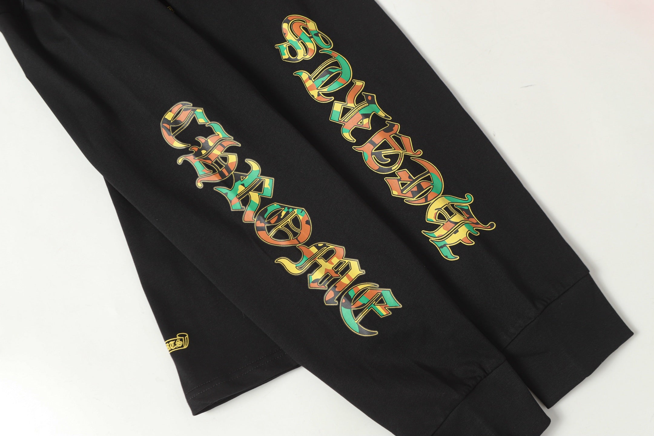 Black long-sleeve shirt sleeve graphic artwork, shown in a close crop