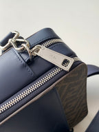 Fendi navy bag corner detail with silver zipper pull, logo plaque, and jacquard trim.