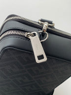 Black crossbody bag with silver hardware, zip pull, and keyring tab