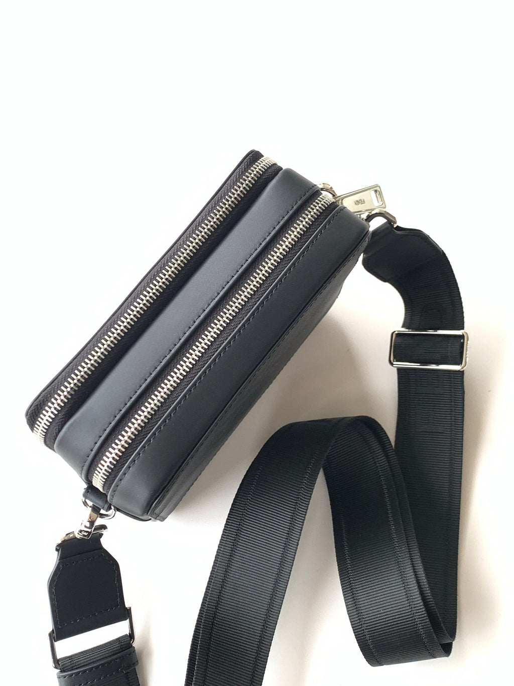 Black crossbody bag with zip closure and adjustable shoulder strap