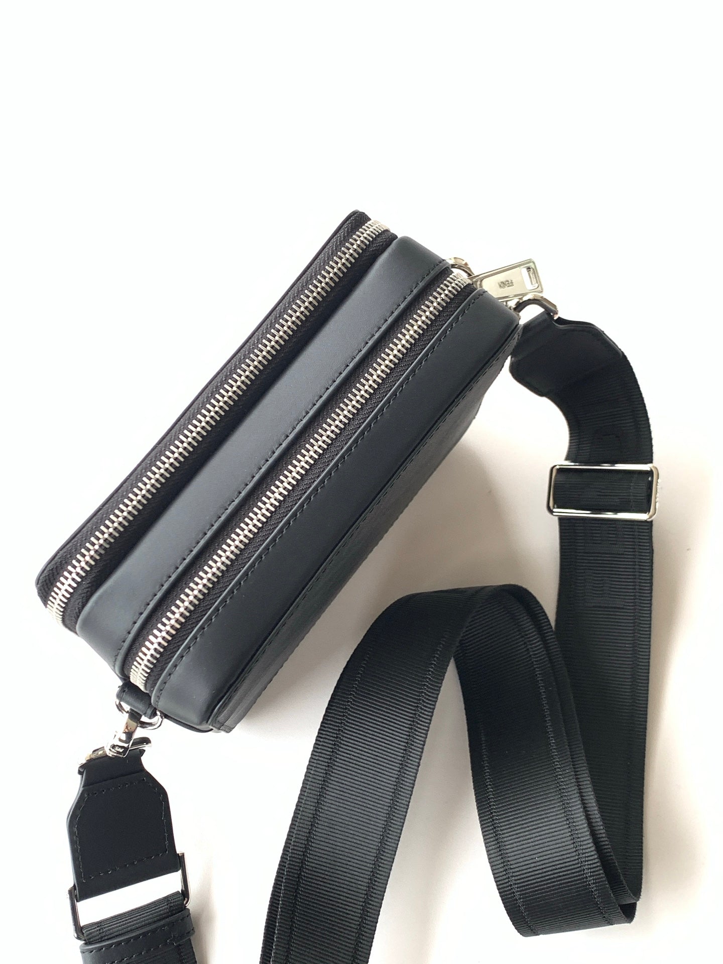 Black crossbody bag with zip closure and adjustable shoulder strap