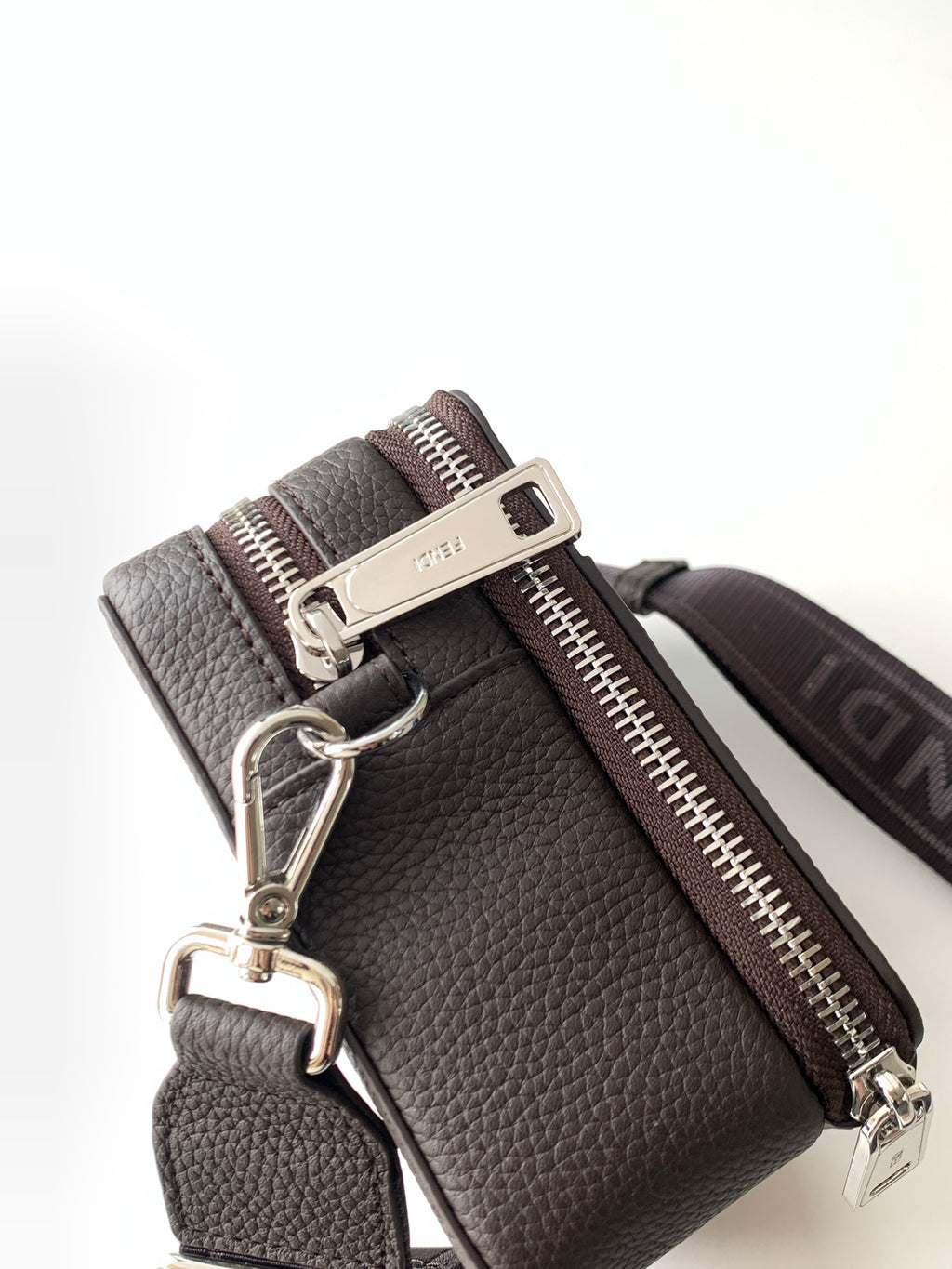 Textured leather mini bag with keyring hardware and dual zip; adjustable strap