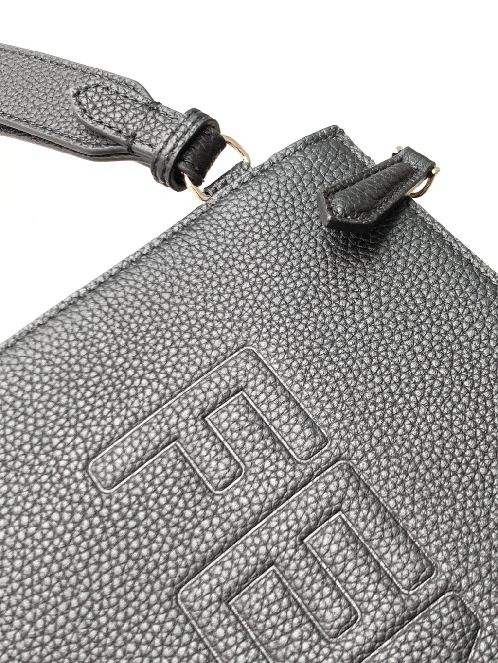 Textured leather bag with stitched Fendi logo and strap attachment