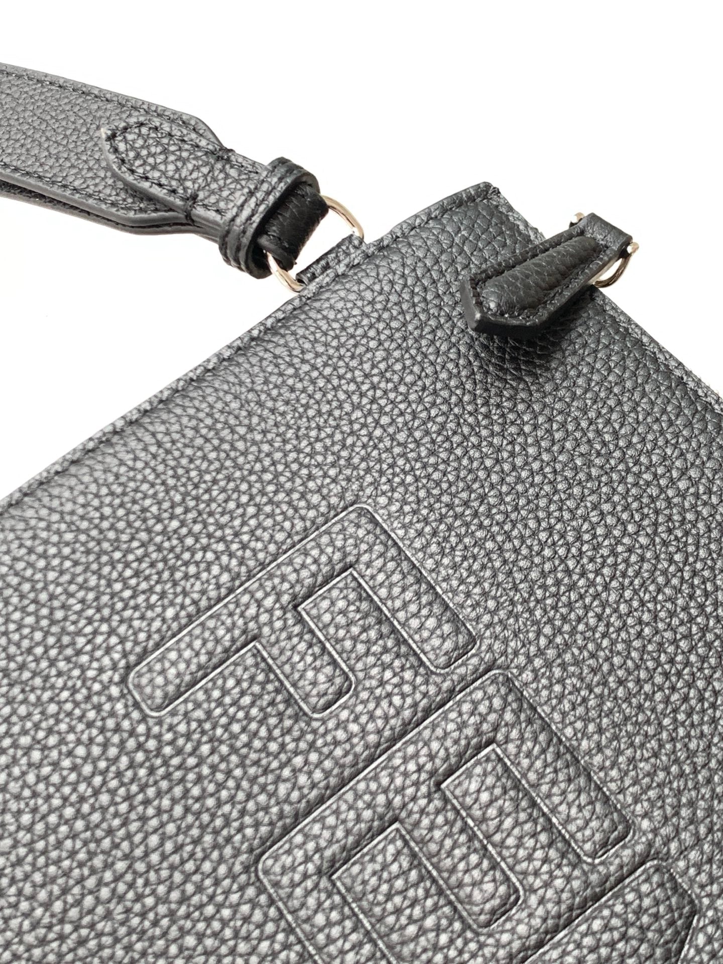 Textured leather bag with stitched Fendi logo and strap attachment