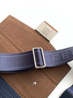 Fendi crossbody strap close-up with silver buckle, navy webbing and tan suede panel
