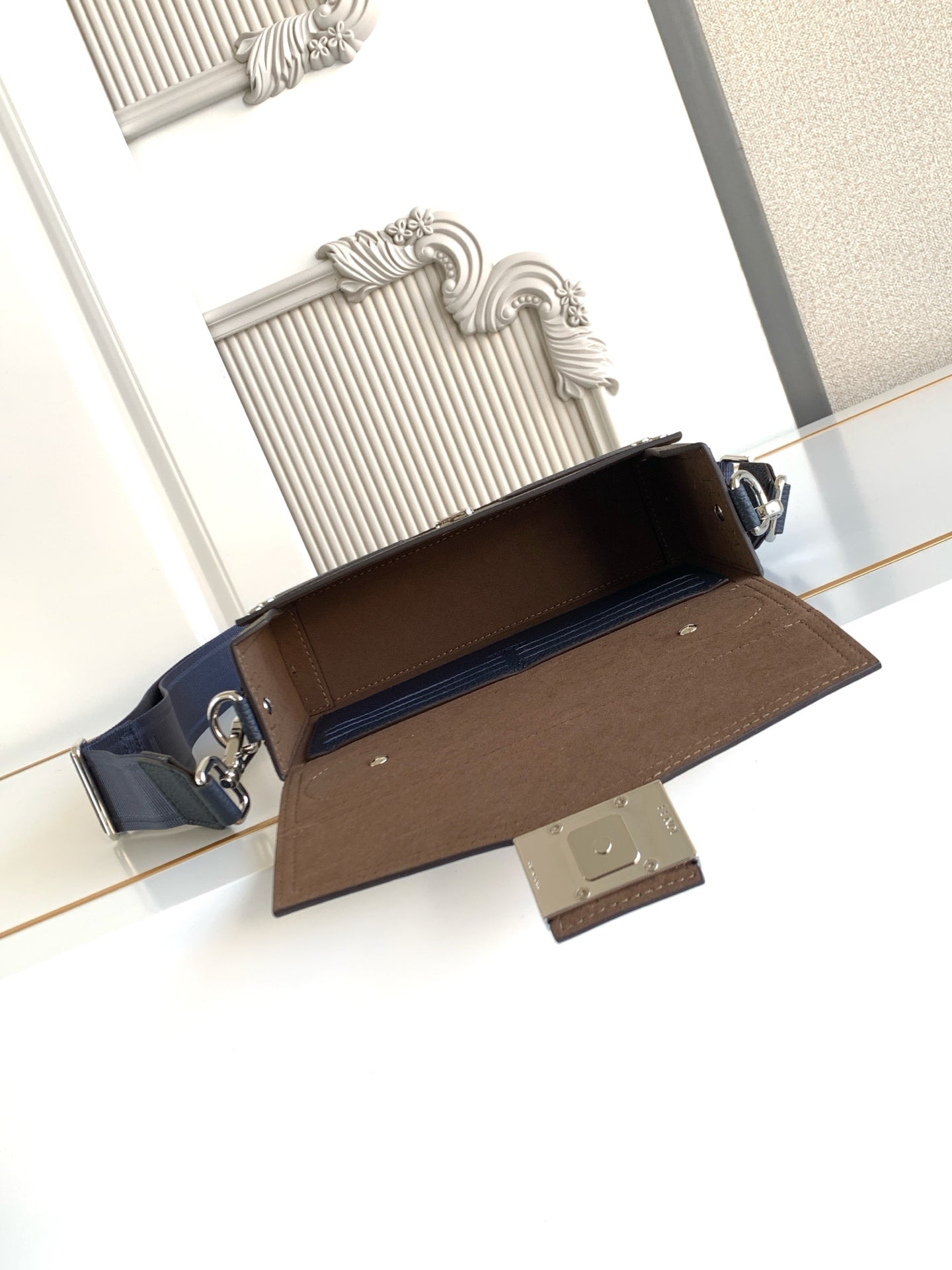 Fendi small crossbody bag open view, blue exterior with brown interior and flap hardware