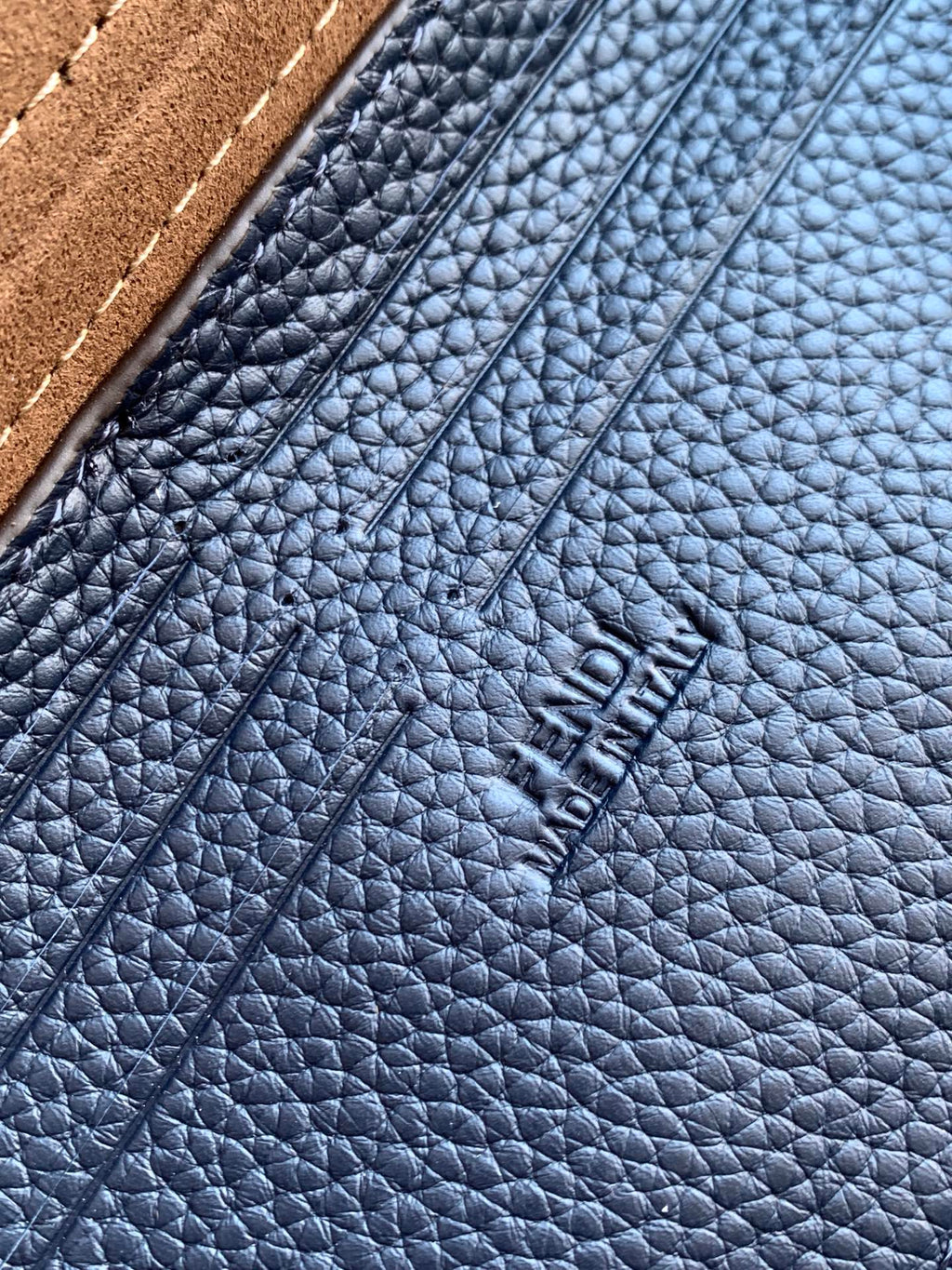 Fendi embossed on blue pebbled leather, close-up of texture and stitching