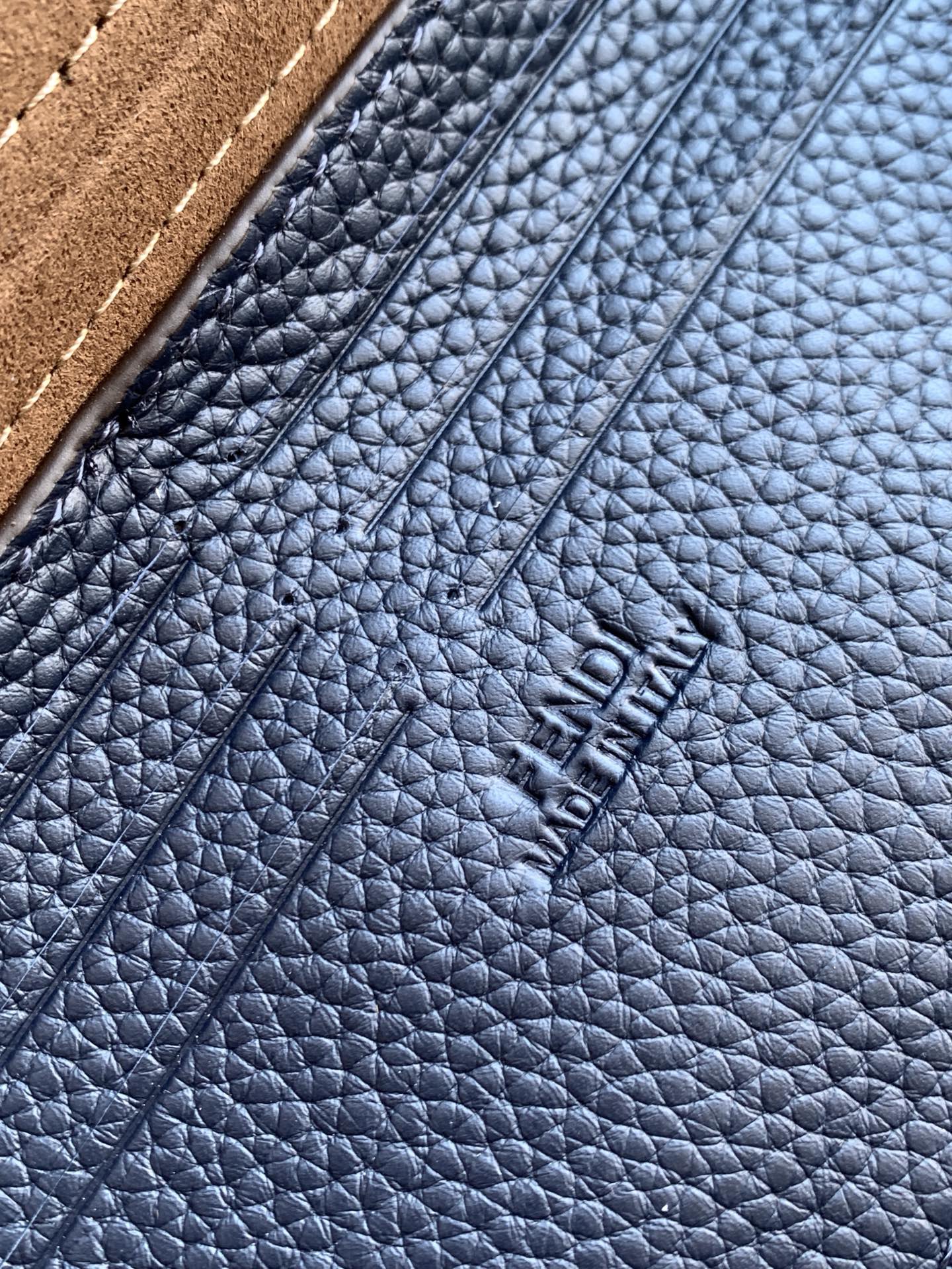 Fendi embossed on blue pebbled leather, close-up of texture and stitching