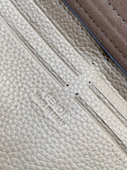 Fendi logo embossed on textured light-beige leather with dark edge trim