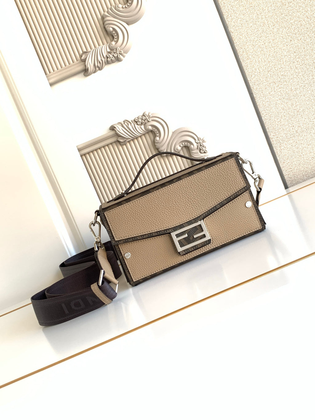 Fendi mini crossbody bag in textured beige with black strap and front logo lock