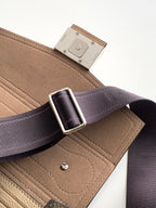 Fendi strap buckle on riveted leather tab attached to textured beige mini bag