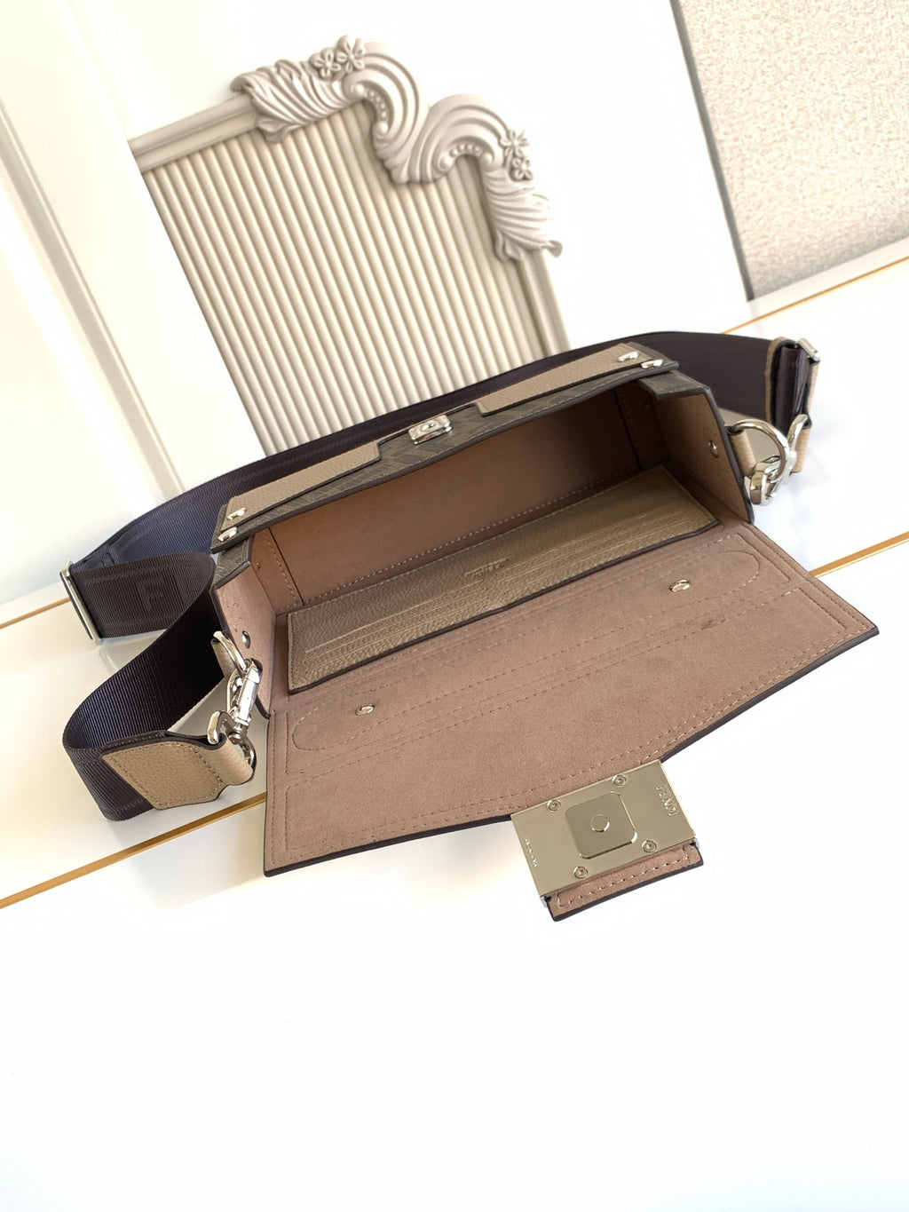 Fendi mini bag open to reveal lined interior and adjustable side hardware