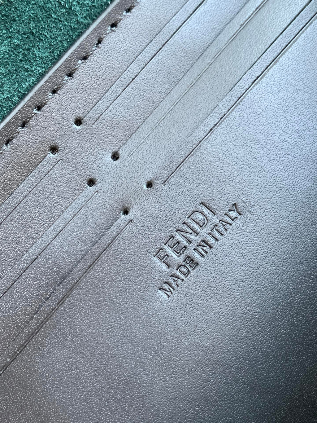 Fendi Made in Italy embossing on gray leather, stitched strap panel close-up