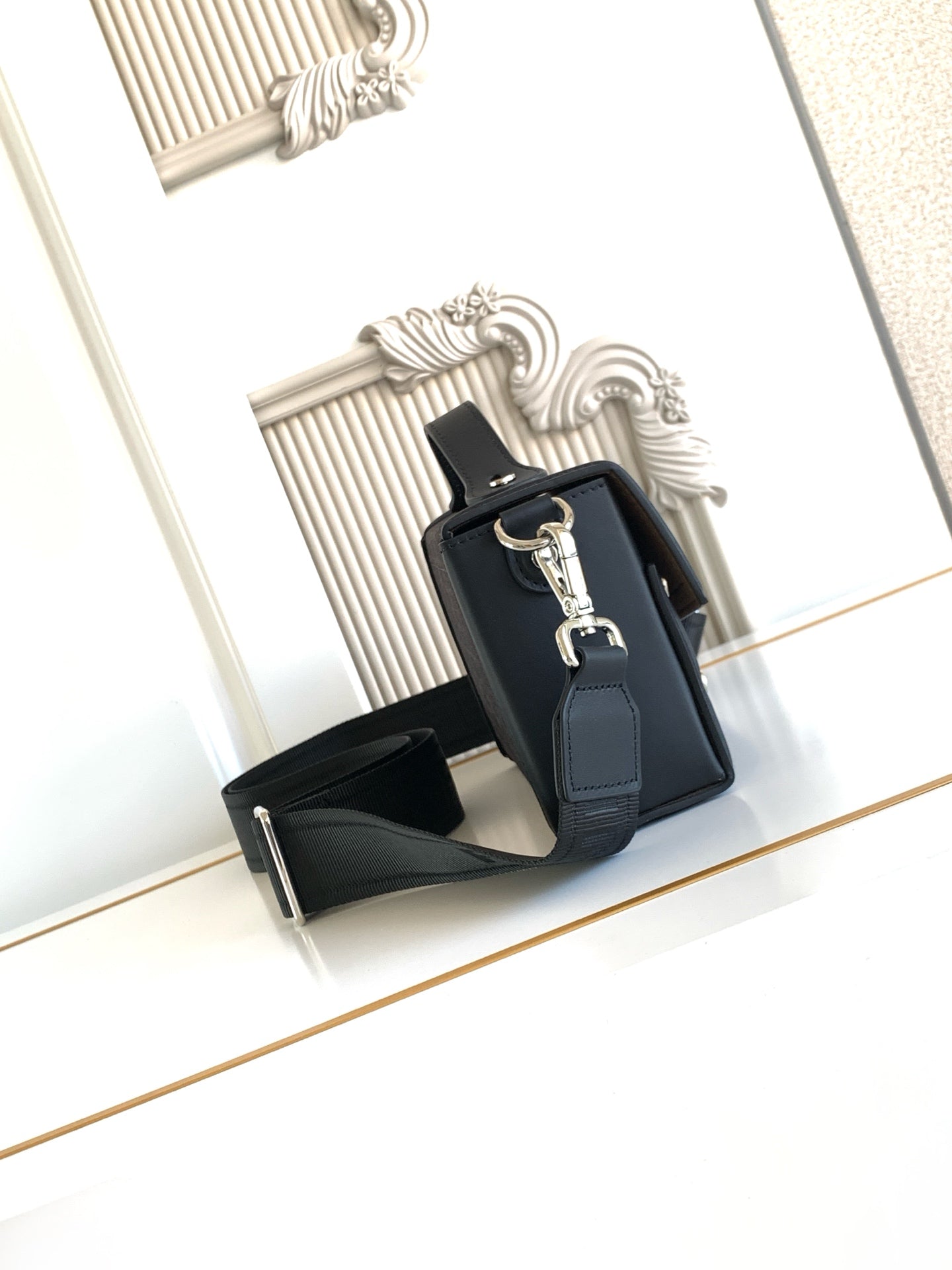 Fendi bag with black body, front clasp hardware, and leather crossbody strap