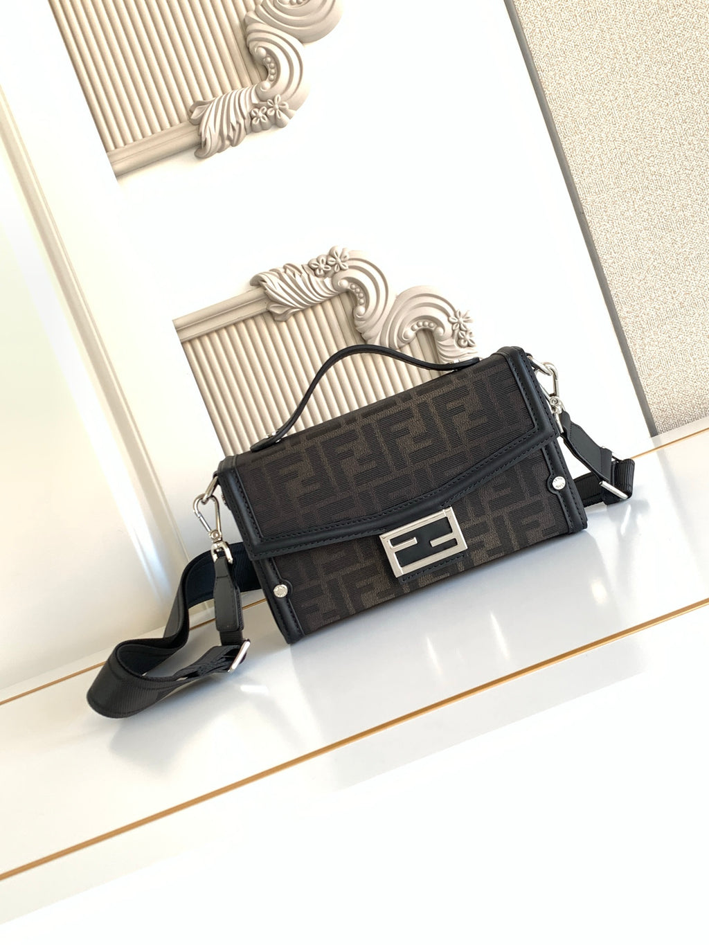 Fendi bag in dark logo canvas with black trim, top clasp, and adjustable shoulder strap