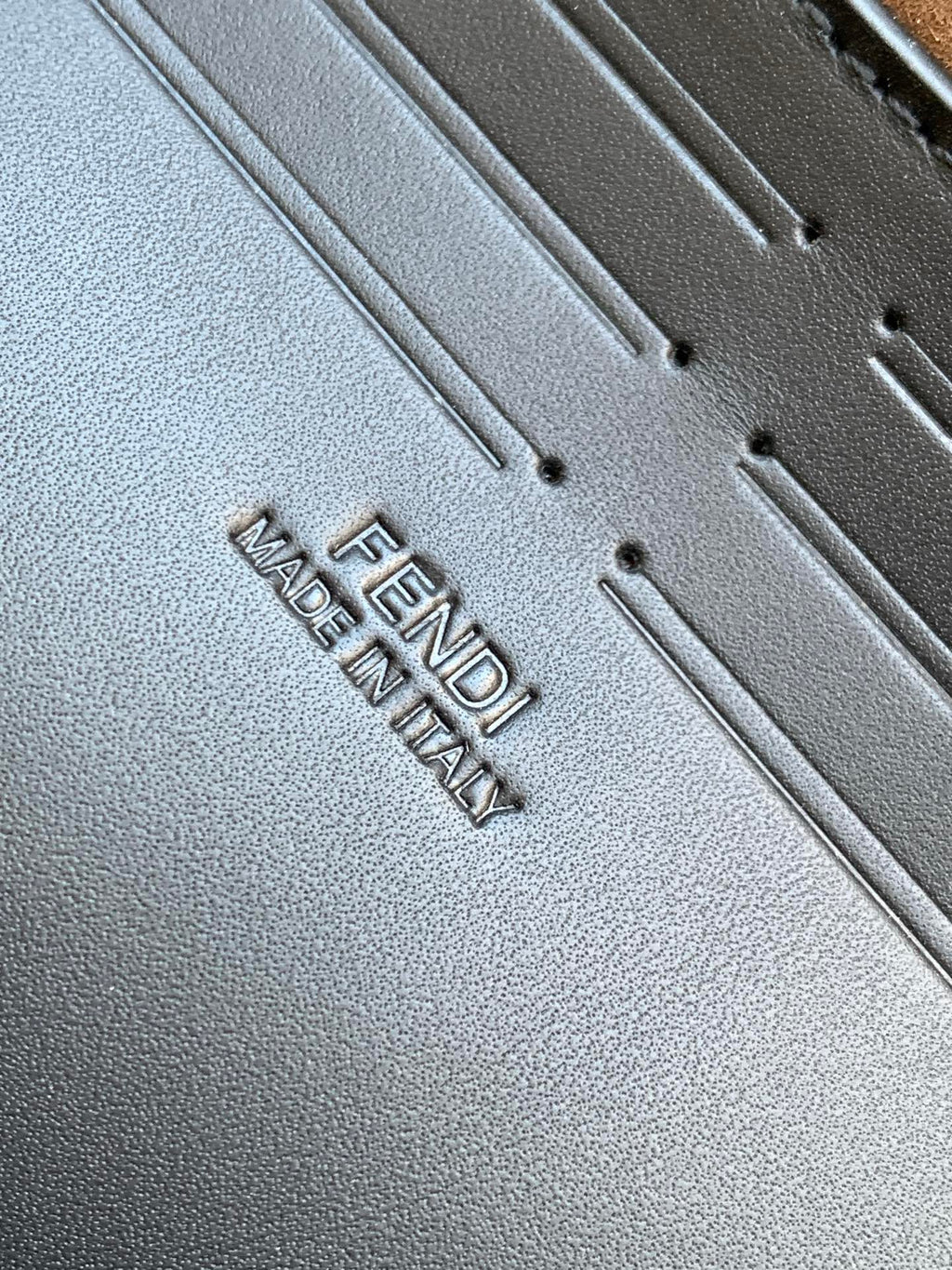 Fendi bag leather close-up with embossed text reading FENDI and MADE IN ITALY