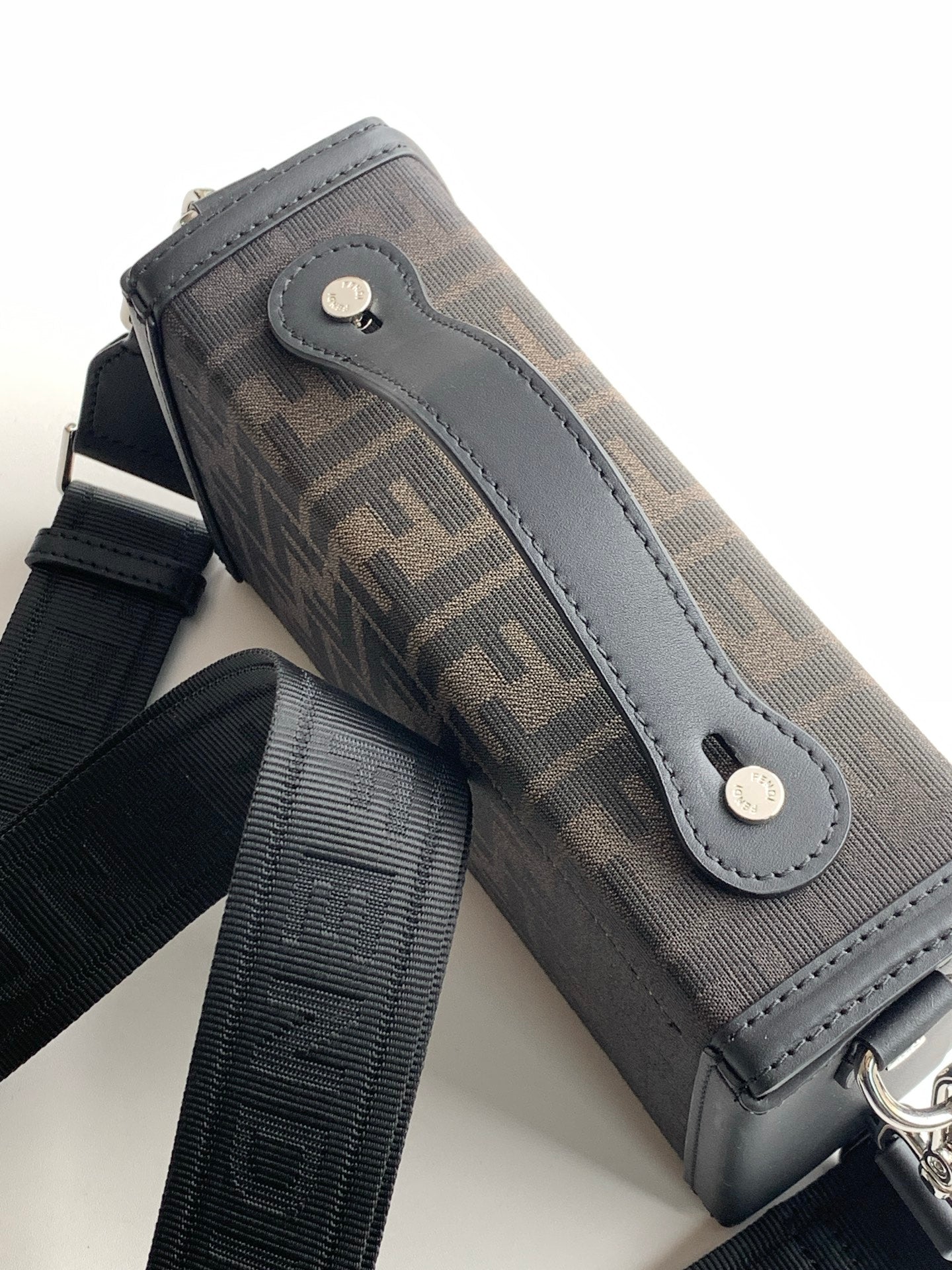 Fendi bag close-up of logo canvas with light gray leather tab and silver rivets