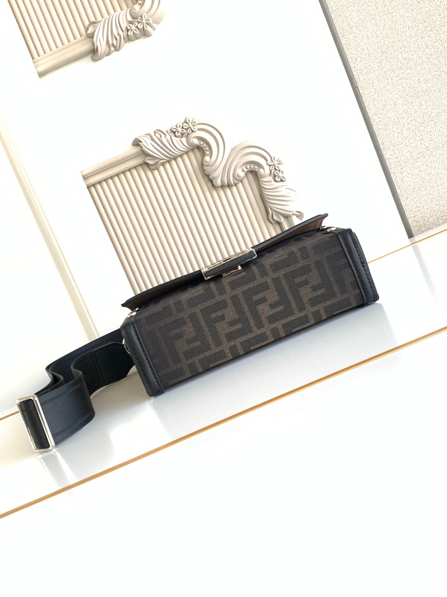 Fendi bag profile view with dark logo front panel and adjustable shoulder strap