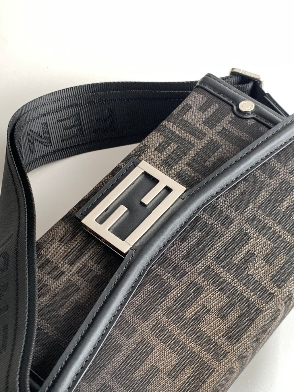 Fendi bag strap detail with dark logo webbing and silver-tone buckle hardware