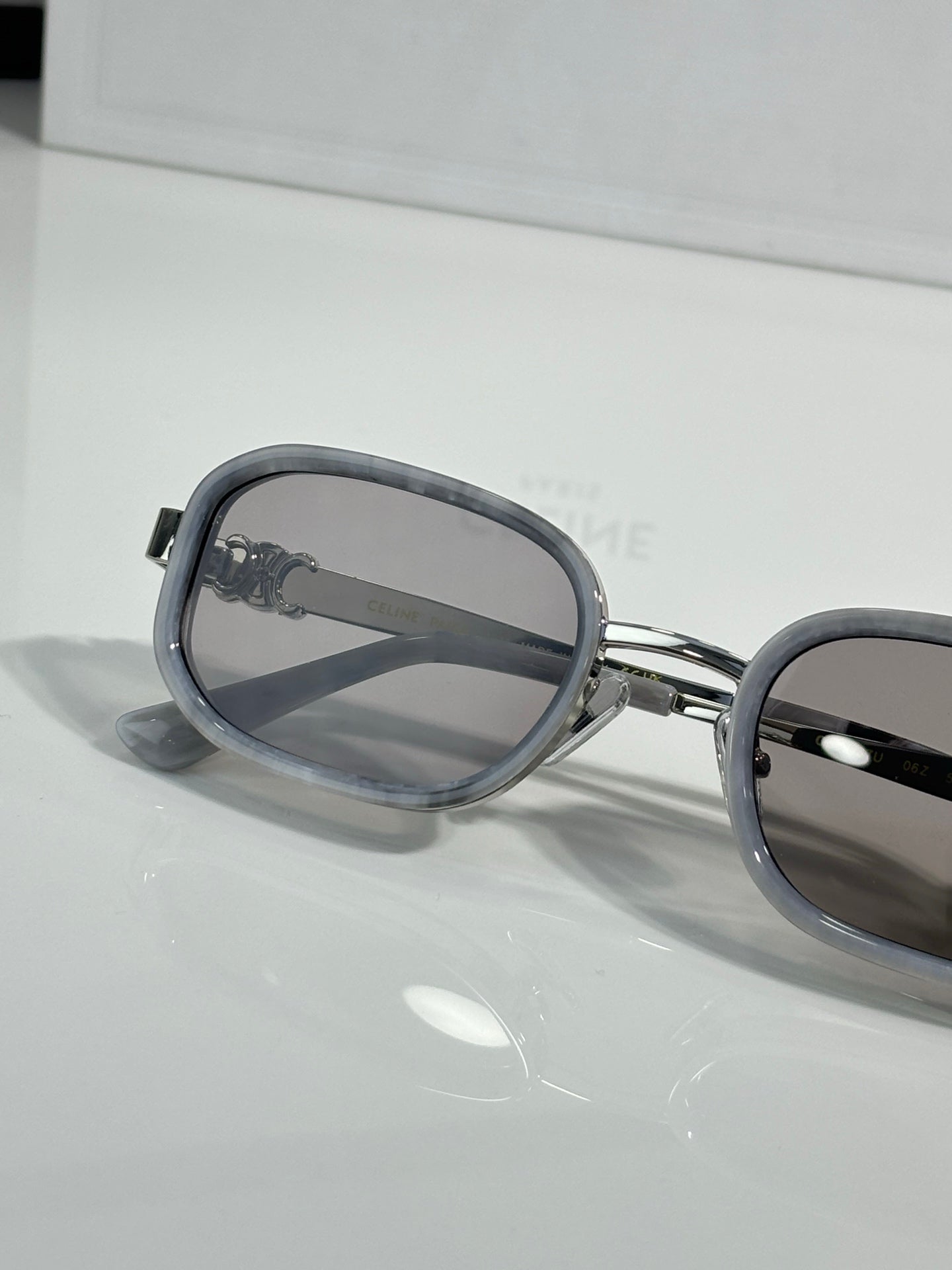 Silver sunglasses with smoky lenses and dark nose bridge detail