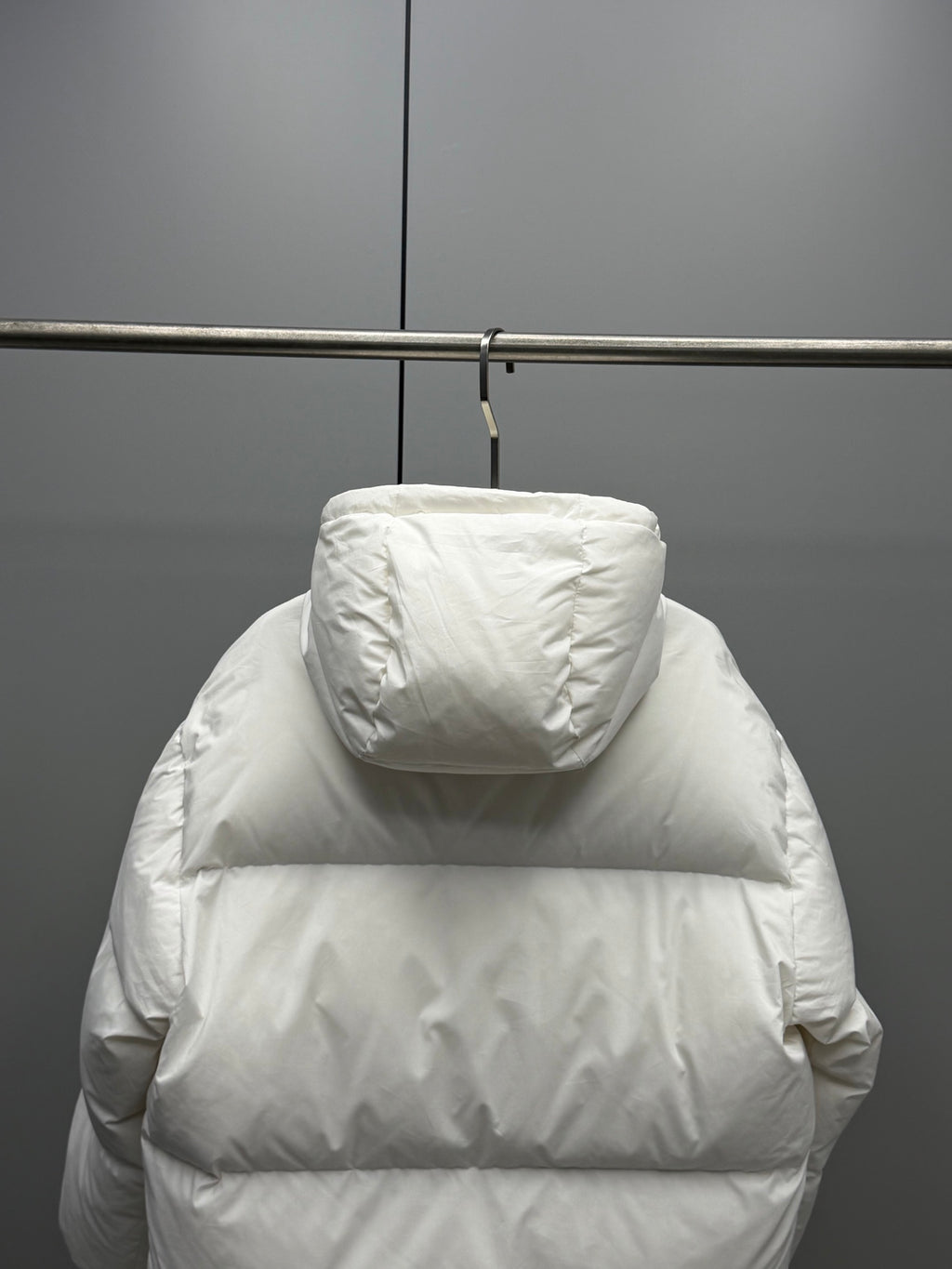 White hooded puffer jacket back view with wide horizontal baffles