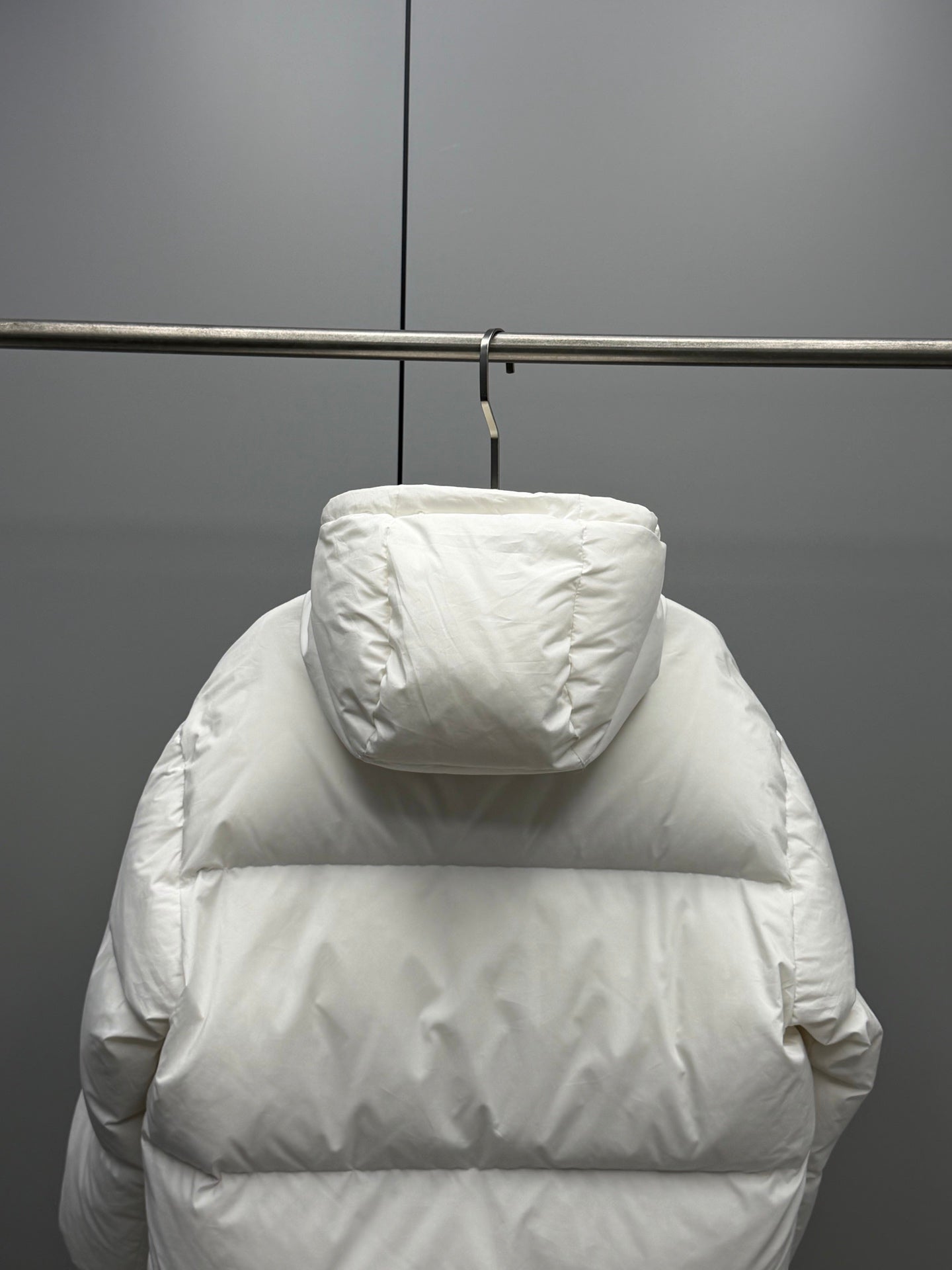 White hooded puffer jacket back view with wide horizontal baffles