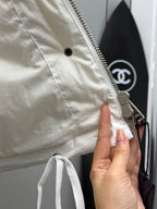 White puffer jacket hood seam with zipper and metal branded pull tab