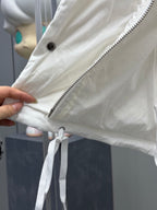 White puffer jacket sleeve detail with zipper and drawstring tie