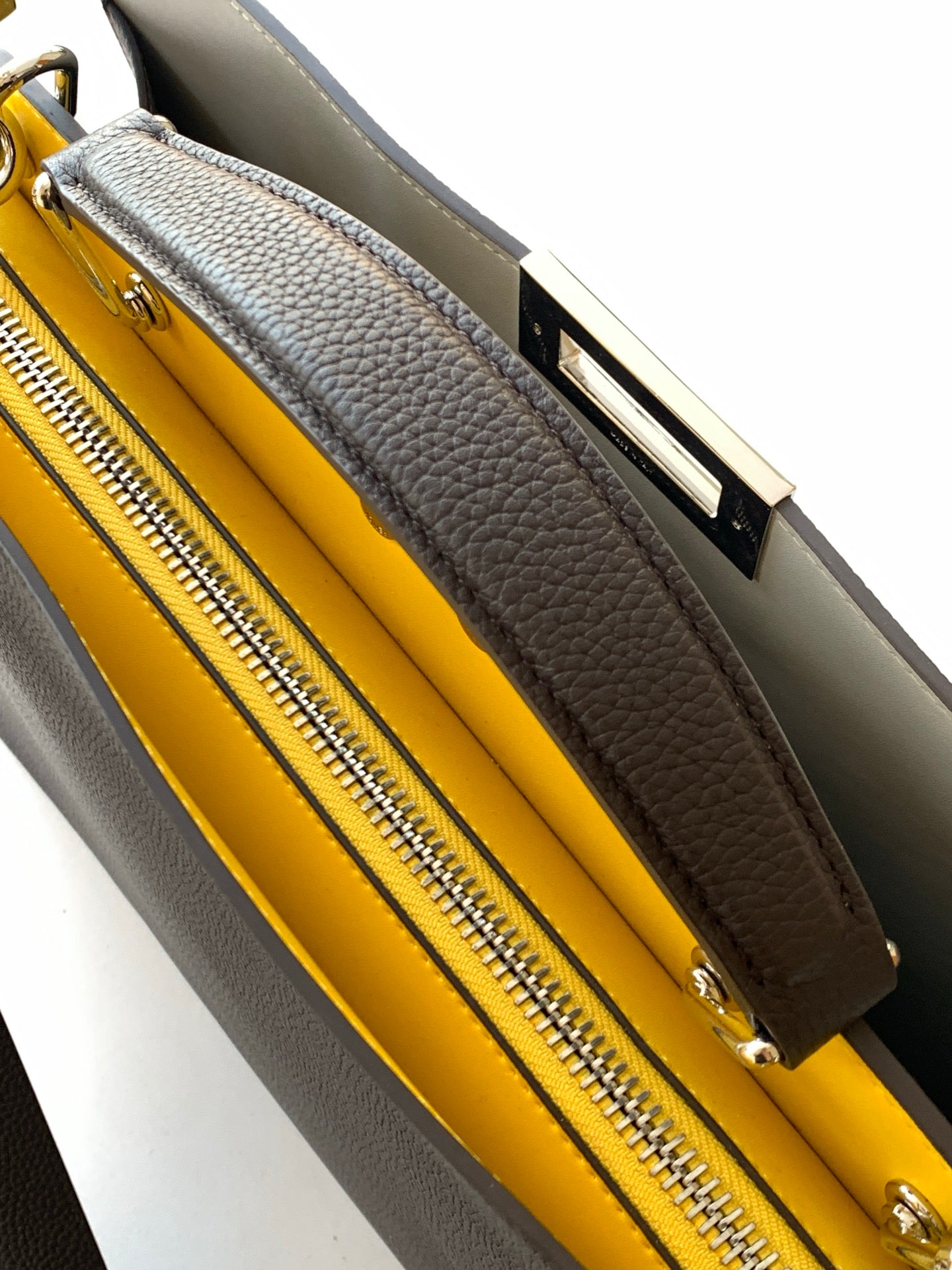 Fendi bag interior with bright yellow lining and zippered compartment