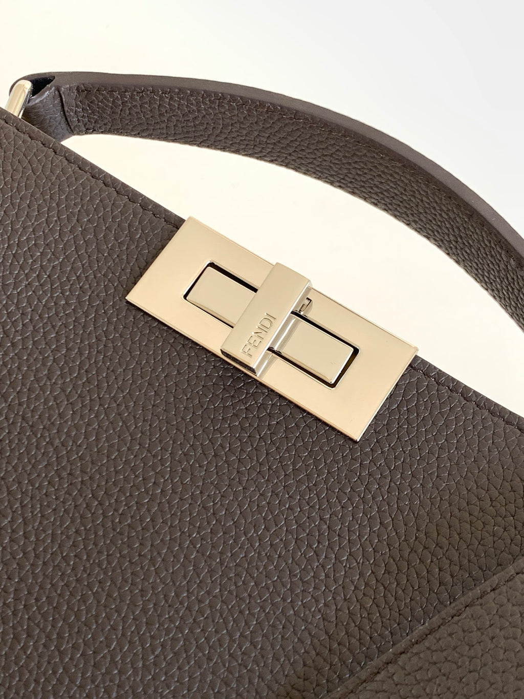 Fendi dark leather belt-style bag with metal buckle and engraved plate