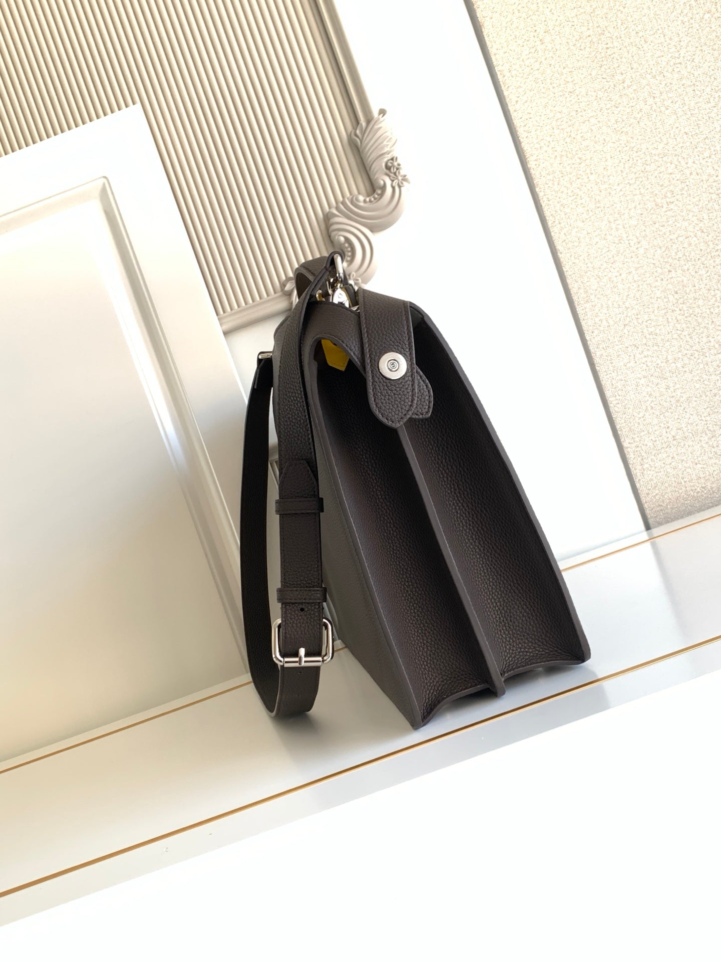 Fendi dark crossbody bag with flap front, front pocket, and adjustable strap