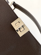 Fendi bag strap clasp close-up with gold-toned metal buckle and engraved logo plate