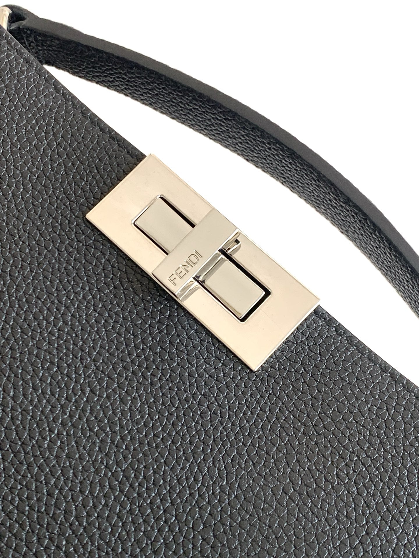 Textured black bag strap with gold-tone buckle and centered Fendi logo plate.