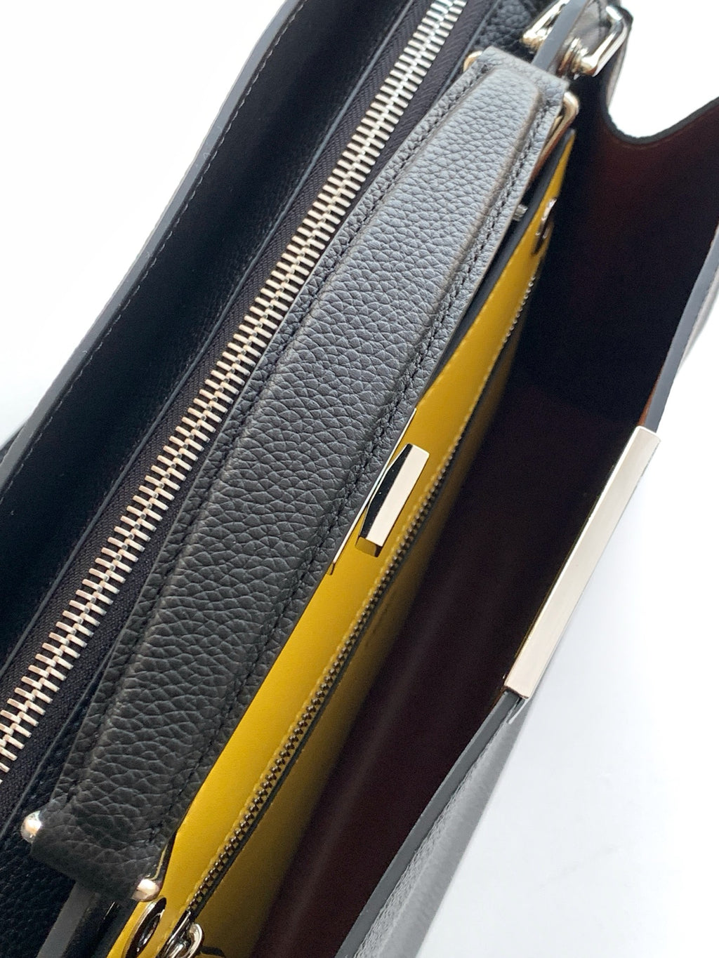Black bag interior with zipper opening and bright yellow lining panel.