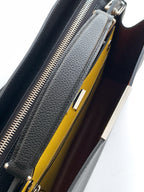 Black bag interior with zipper opening and bright yellow lining panel.