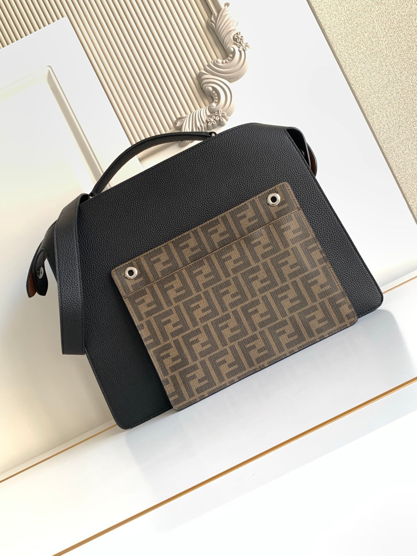 Black crossbody bag with flap and FF monogram front panel pocket.
