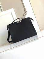 Black crossbody bag with flap, curved handle, and side strap details.