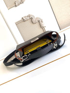 Black leather shoulder bag open to yellow interior with zip pocket