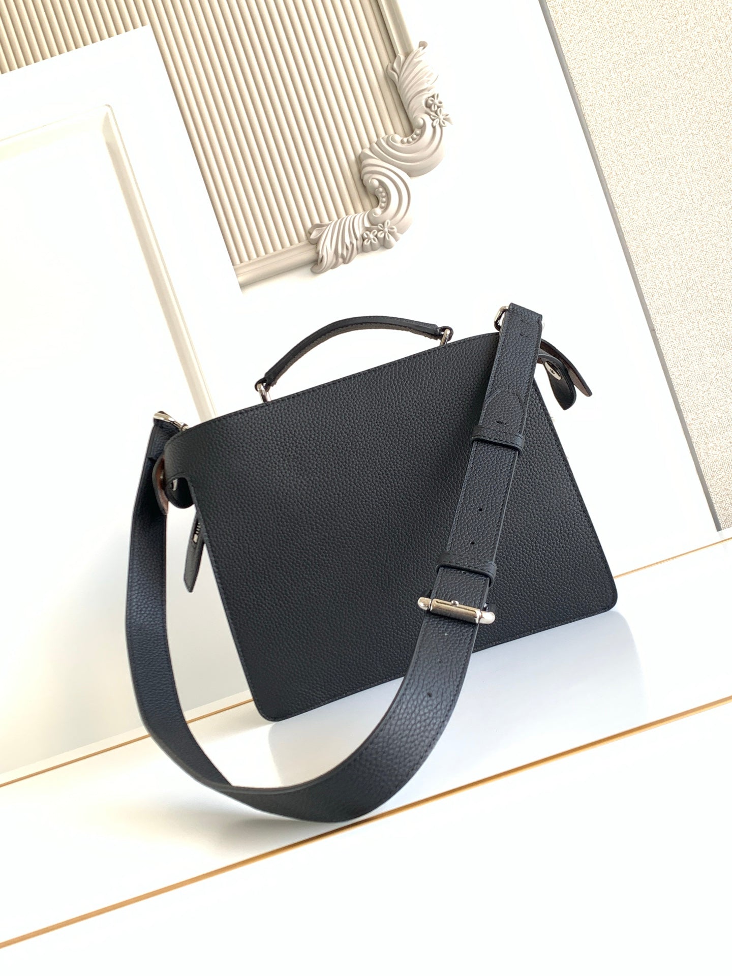 Black leather shoulder bag with silver buckle and top handle