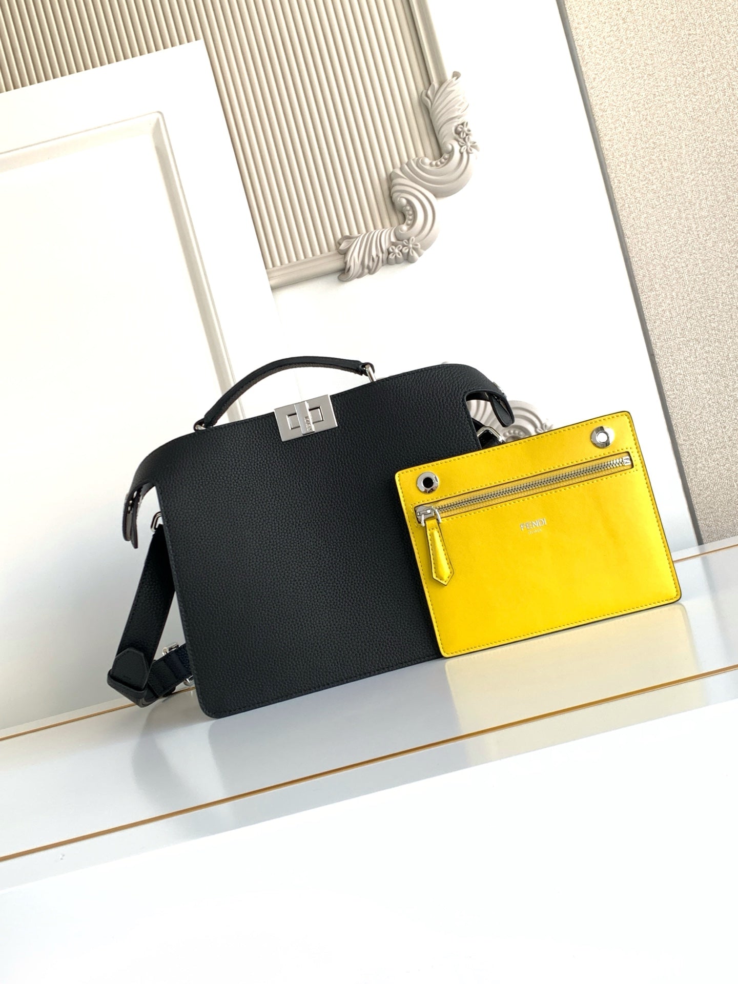 Black leather shoulder bag with bright yellow front pocket and shoulder strap