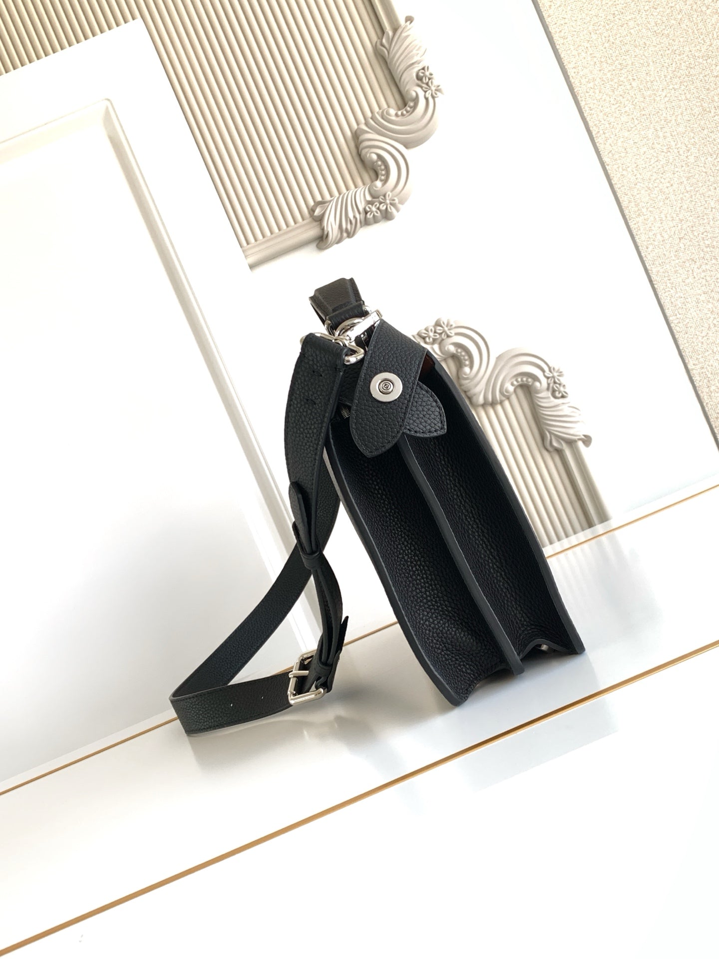 Black leather shoulder bag with strap and front snap-flap pocket