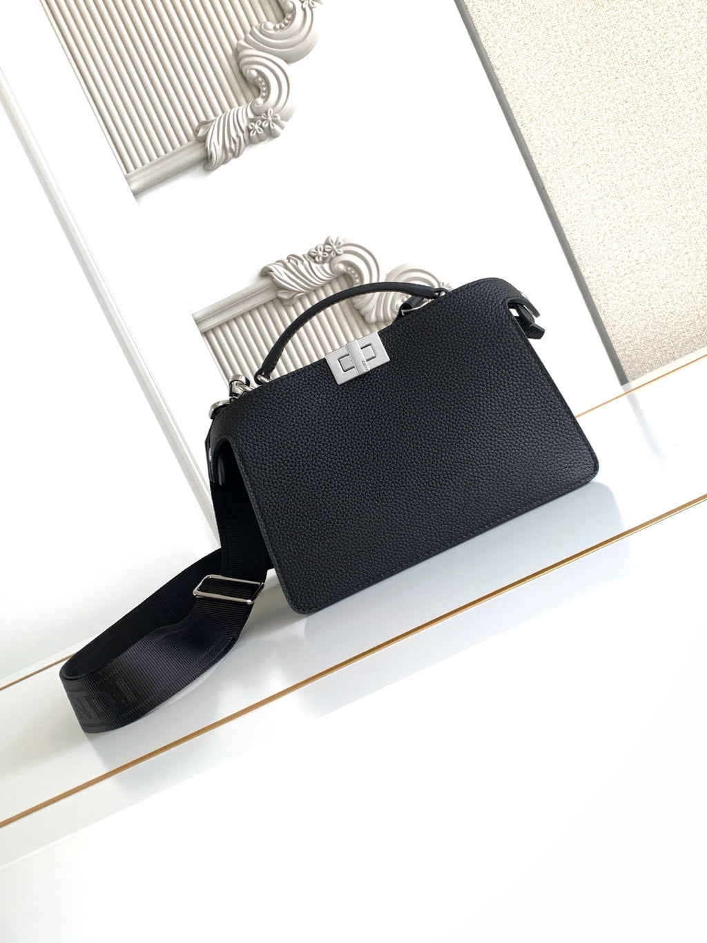 Black pebbled leather handbag with top handle and crossbody strap