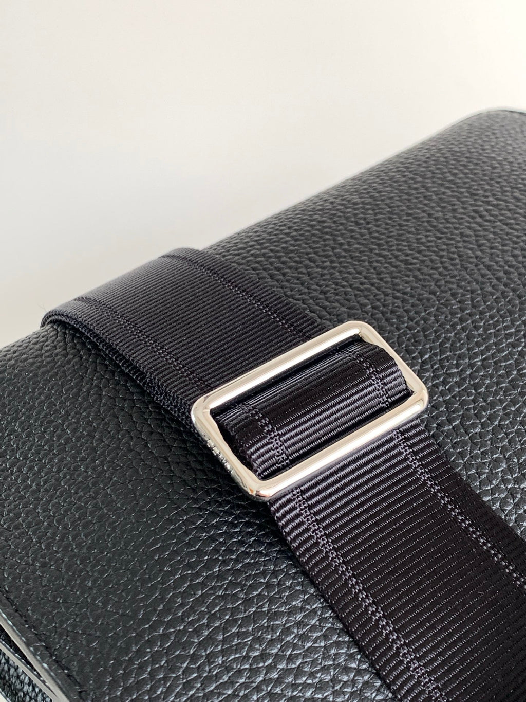 Black textured leather strap with metal adjuster and ribbed webbing