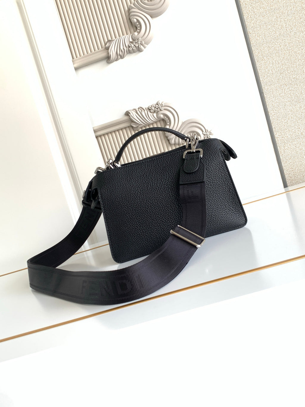 Black pebbled leather handbag with adjustable shoulder strap and buckle