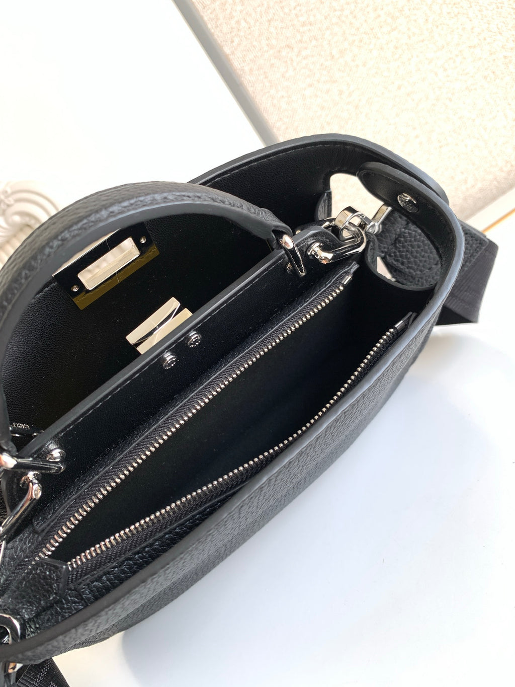 Black pebbled leather bag interior with zipper, studs, and hardware