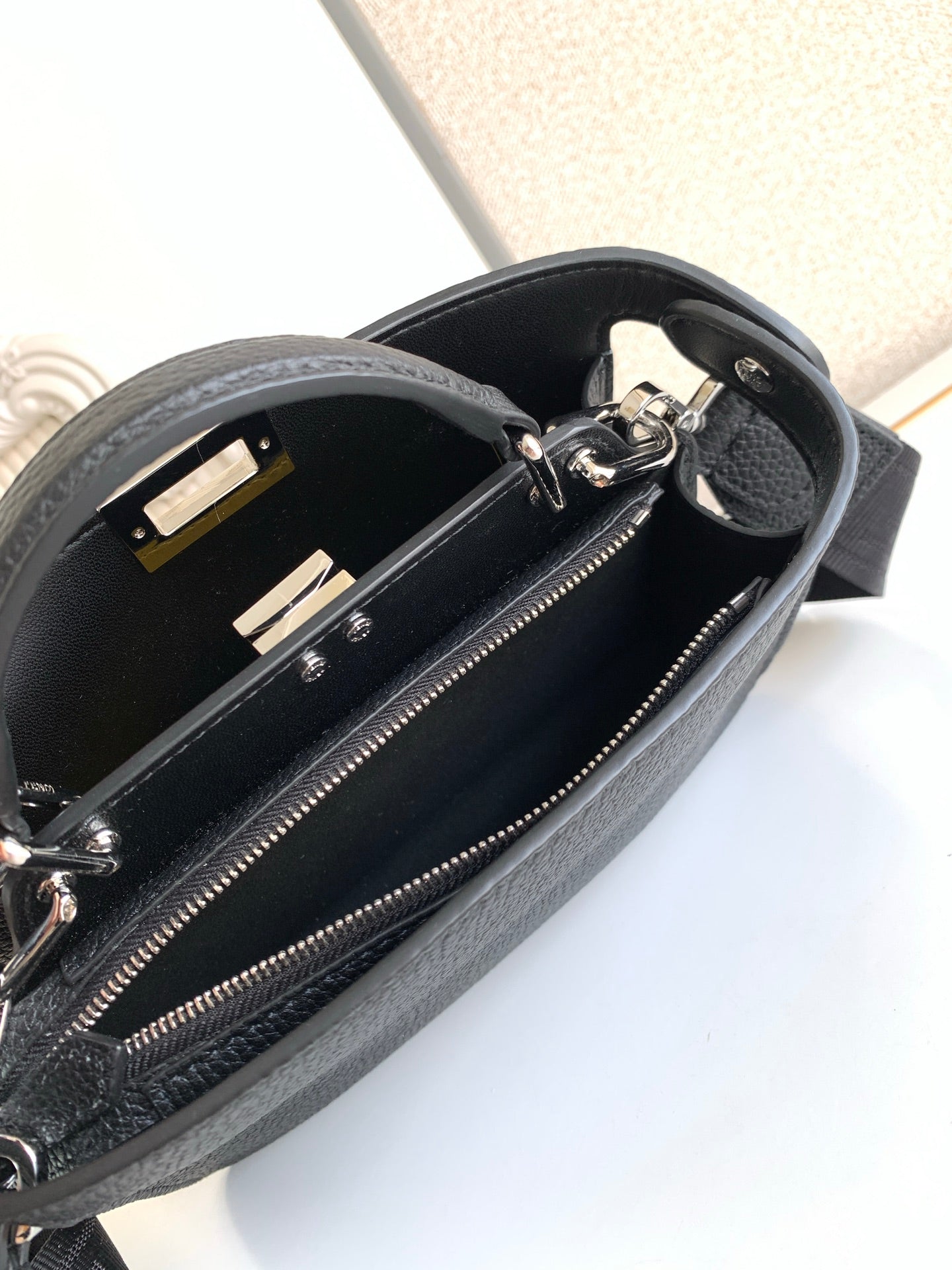 Black pebbled leather bag interior with zipper, studs, and hardware